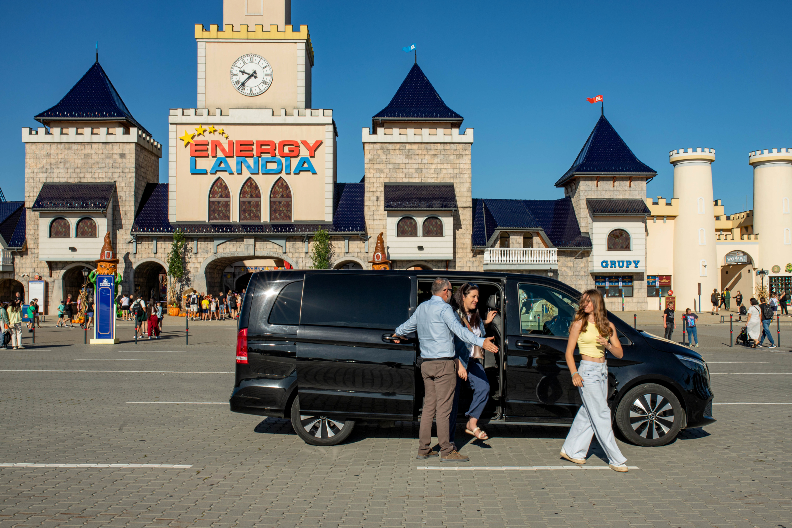 Transfer to Energylandia entrance KrakowDirect minivan drop-off in front of the Energylandia entrance, guests arriving for a full-day trip.